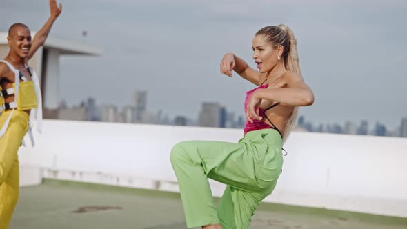 Two Fashion Models Dancing And Laughing In Clubwear On City Roof