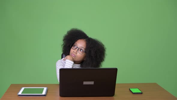 Young Cute African Girl with Afro Hair Using Laptop