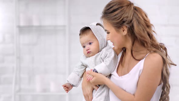 Caring Beautiful Young Mother Hugging and Kissing Little Son Having Love Feeling Medium Closeup