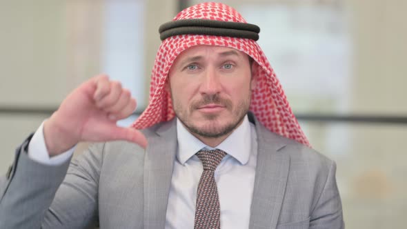 Portrait of Middle Aged Arab Businessman showing Thumbs Down Gesture