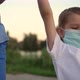 A Family with a Child in Medical Masks Walk Near the Lake - VideoHive Item for Sale