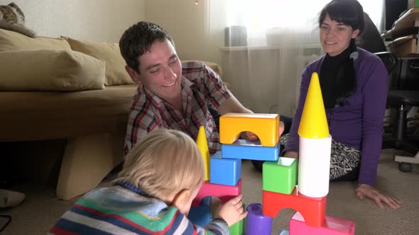 Happy Family Father Mother Son Play Toy Bricks In Room