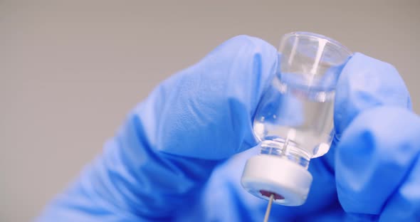 Extreme Close Up of Hand Holding Syringe and Vaccine in Hand in Laboratory.