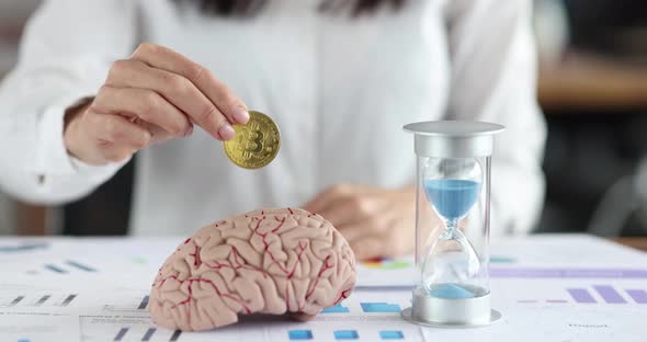 Female Hand Inserts Bitcoin Coin Into Human Brain