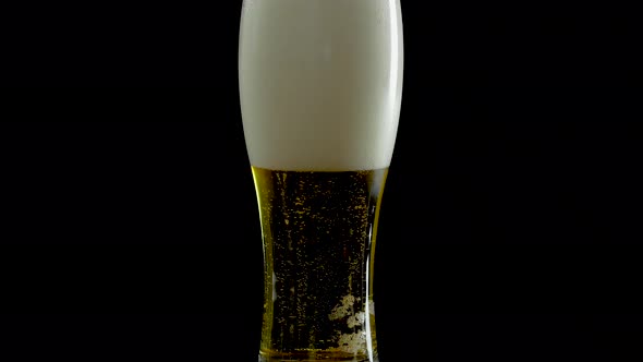 Light Beer In A Glass With Bubbles,Draft Beer In A Glass On A Black Background