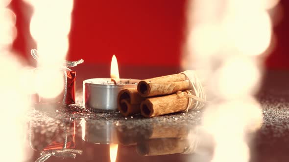 View of candle burning next to little christmas present