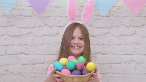 Portrait of Funny Easter Kid Wearing Bunny Ears with Colorful Eggs