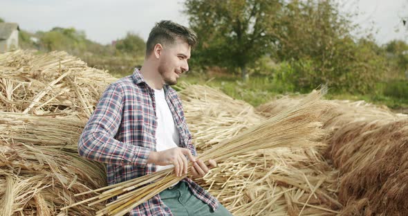 Farmer Smiling and Making Traditional Straw Broom with Sorghum Natural Broom