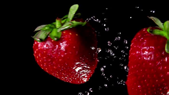 Two Large Juicy Delicious Strawberries Are Colliding on the Black Background