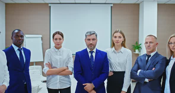 Young Businessmen of Different Nationalities Stand Together and Look Purposefully, the Camera Is