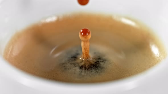 Super Slow Motion Detail Shot of Coffe Drop Falling Into Fresh Espresso at 1000 Fps