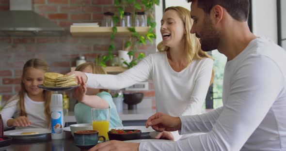 Family having food at dining table in kitchen at comfortable home 4k