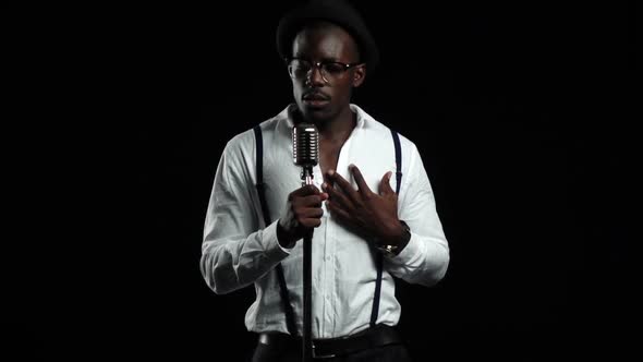 Male African American Musician Singing in a Recording Studio. Black Background. Slow Motion