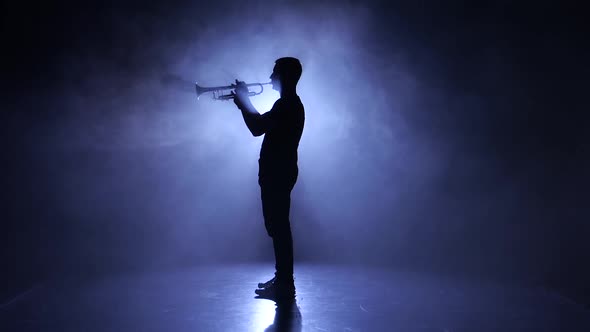 Professional Musician in Smoky Studio Playing on Wind Instrument, Silhouette