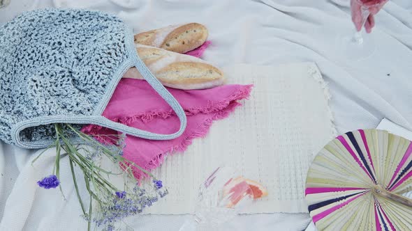 A Glass Of Rose Wine in a luxury romantic picnic date on a white blanket at the beach - Close Up Sho