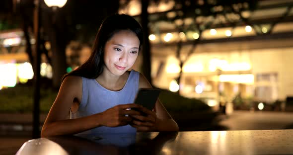 Woman using mobile phone at night 