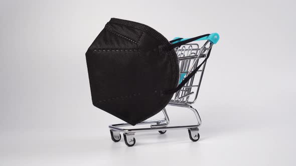 Supermarket trolley with black medical protective mask KN95 closeup 