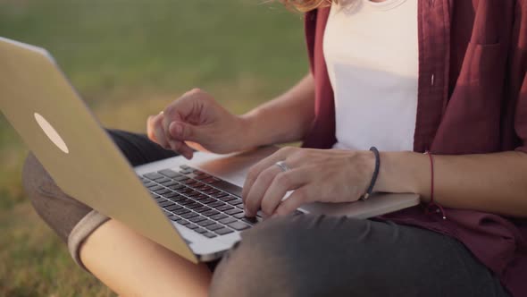 Girl Working with a Laptop on the Lawn