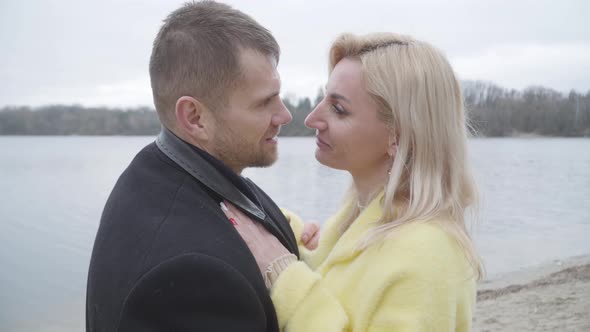 Smiling Blond Woman Dancing with Husband or Boyfriend on Riverbank