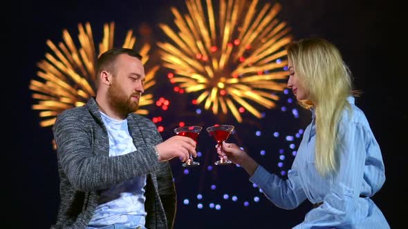 Two Loving People Celebrating Knock Glasses Wine on Date with Colorful Firework.