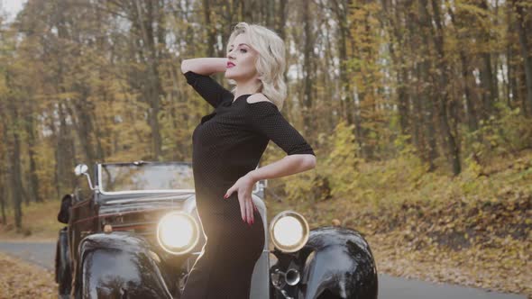 Beautiful Model Poses at Retro Cabriolet in Autumn Park