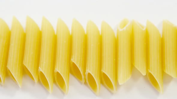 Close up of penne pasta on white background