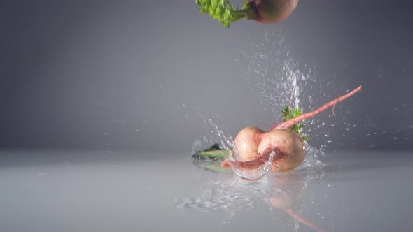 White radishes falling on water surface. Slow Motion.