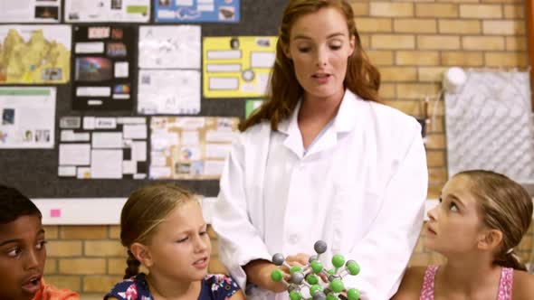 Teacher explaining a kids about molecular model in laboratory