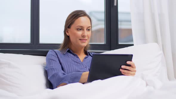 Young Woman with Tablet Pc in Bed at Home Bedroom