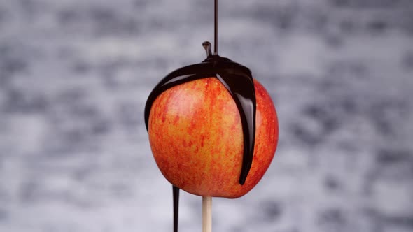 Chocolate Sauce Spilling on Apple on Stick