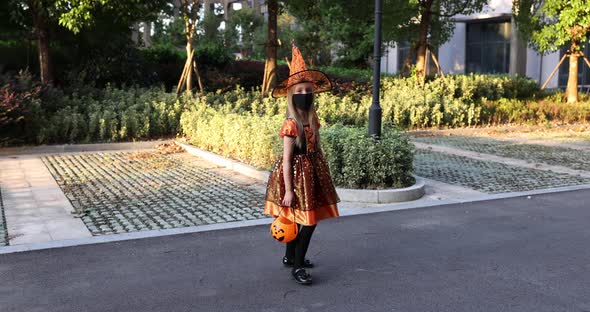 Cute Little Caucasian Girl with Blonde Hair Seven Years Old in Costume of Witch with Hat and Black