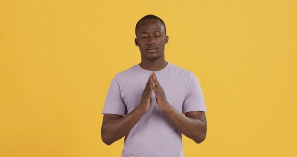 Peaceful Black Man Praying Clasping Hands Orange Background