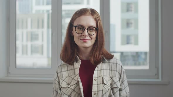 Woman with Red Hair Smiling and Posing at Camera