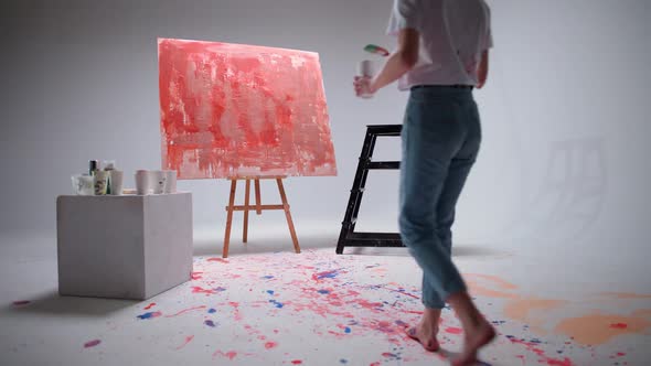Slow Motion Female Artist Draws with a Brush on a Large Canvas in a White Room a Talented Artist