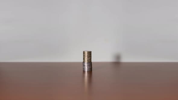 Coins in Stop Motion Increase Upwards on a Piece of Furniture