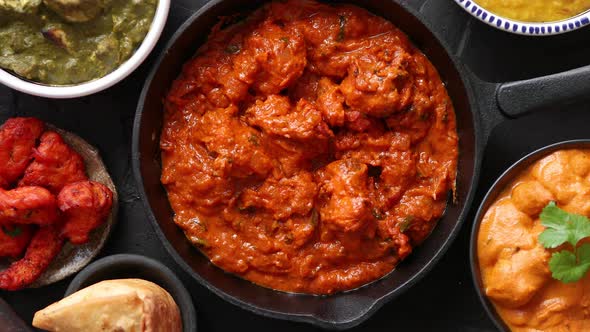 Various Indian Dishes on a Table. Spicy Chicken Tikka Masala in Iron Pan