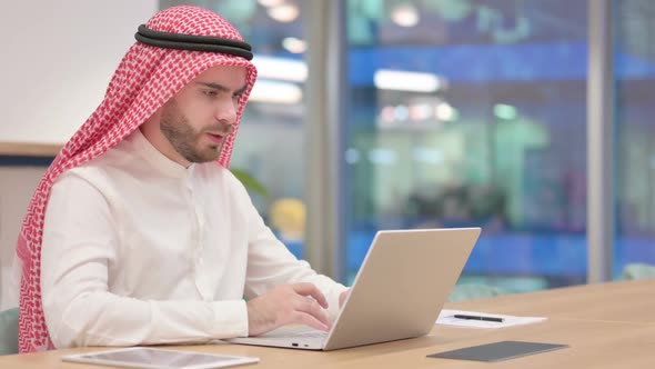 Sick Arab Businessman with Laptop Coughing in Office