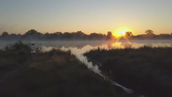 Aerial drone view of a sunset sunrise over a lake with fog in Africa