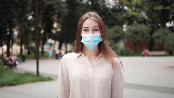 Pandemic, portrait of a young tourist girl in protective medical face mask on the street.