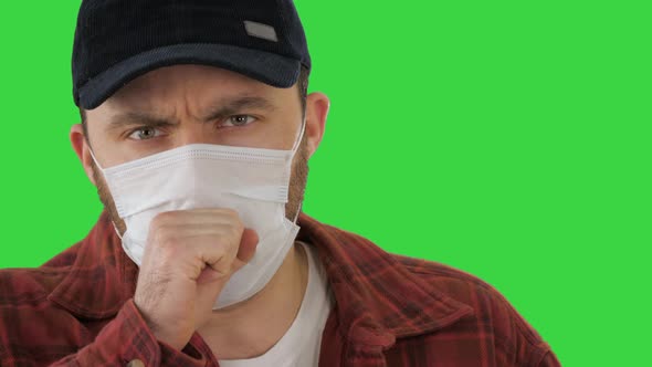 American Farmer in Medical Mask Coughing on a Green Screen, Chroma Key.