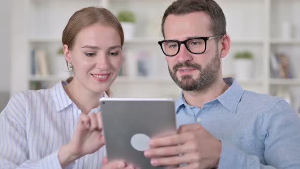 Portrait of Hardworking Young Couple Using Tablet