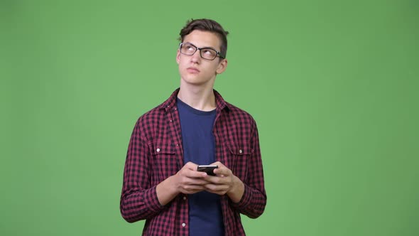 Young Handsome Teenage Nerd Boy Using Phone