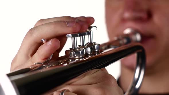 Fingers of Man Pushing Button on Trumpet. White Background Studio