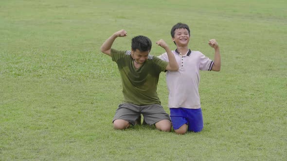 Asian Kids Celebrating A Goal On Grass