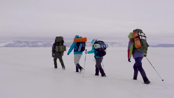 Four Young People Go Hiking in the Snowy Desert.
