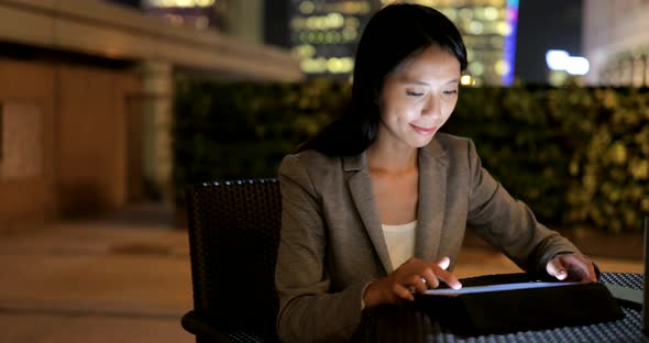 Businesswoman use of tablet computer at night 