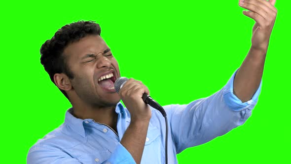 Enthusiastic Man Singing with Microphone on Green Screen