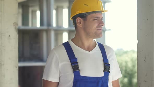 Construction Worker Smiling and Looking Away on a Sky Background