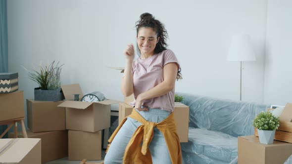 Asian Woman is Dancing in Modern Apartment After Relocation Enjoying Music in Free Time at New Home