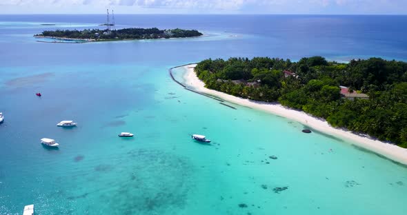 Wide angle flying abstract shot of a sunshine white sandy paradise beach and blue water background i